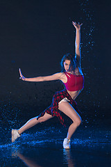 Image showing The young beautiful modern dancer dancing under water drops