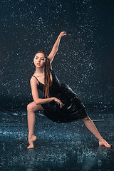 Image showing The young beautiful modern dancer dancing under water drops