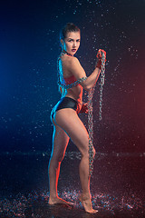 Image showing Young tanned fit woman with beautiful sporty buttocks and slim with water drops