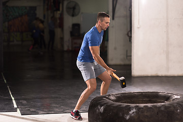 Image showing man workout with hammer and tractor tire