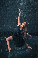 Image showing The young beautiful modern dancer dancing under water drops