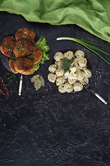 Image showing Fried cutlets and russian pelmeni on black background