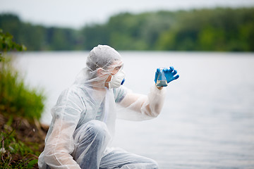 Image showing Biologist with test-tube near river