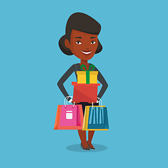 Image showing Happy woman holding shopping bags and gift boxes.