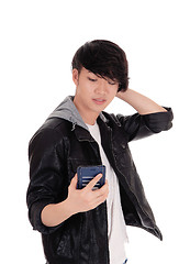 Image showing Asian teenager looking at his cellphone.