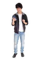 Image showing Asian teenager looking at his cellphone.