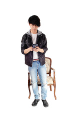 Image showing Asian teenager looking at his cellphone.