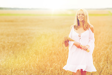 Image showing happy young woman with spikelets on cereal field