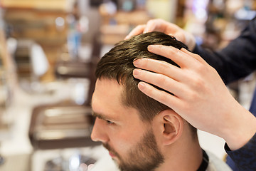 Image showing man and barber styling hair at barbershop