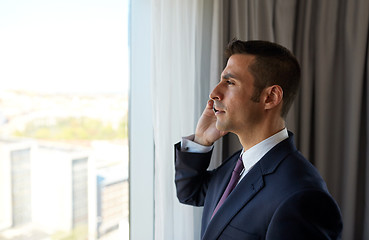 Image showing businessman calling on smartphone at hotel room