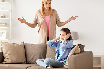 Image showing girl closing ears to not hear angry mother at home