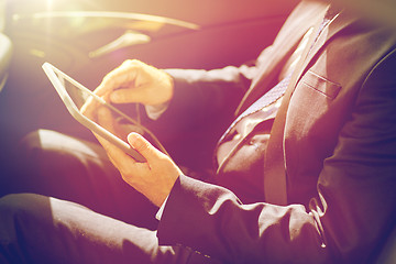 Image showing senior businessman with tablet pc driving in car