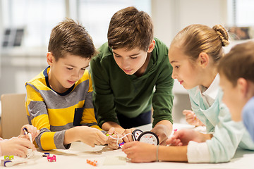 Image showing happy children building robots at robotics school