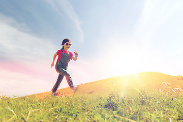 Image showing happy little girl running on green summer field