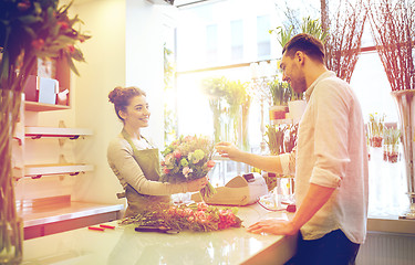 Image showing smiling florist woman and man at flower shop