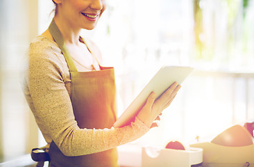 Image showing close up of woman with tablet pc at flower shop