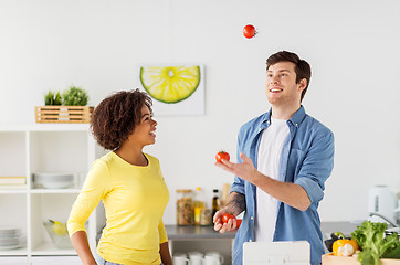 Image showing couple cooking food and juggling tomatoes at home