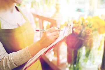 Image showing close up of woman with clipboard at flower shop