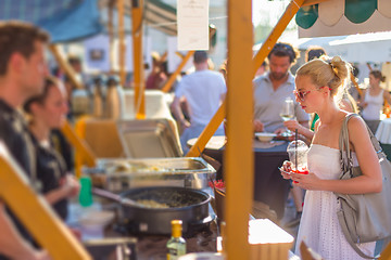 Image showing Woman buying meal at street food festival.