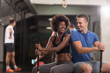 Image showing multiethnic couple after workout with hammer