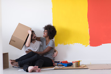 Image showing young multiethnic couple playing with cardboard boxes