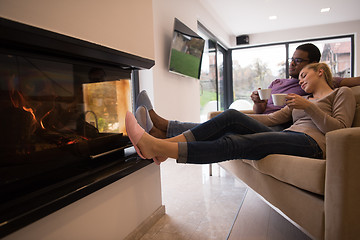 Image showing Young multiethnic couple  in front of fireplace