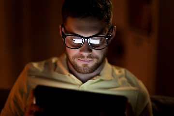 Image showing young man with tablet pc networking at night