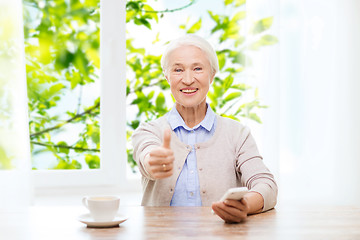 Image showing senior woman with smartphone showing thumbs up