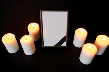 Image showing photo frame with black mourning ribbon and candles