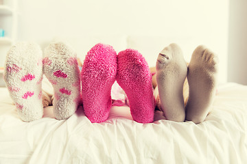 Image showing close up of women feet in socks on bed at home