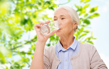 Image showing happy senior woman with glass of water at home