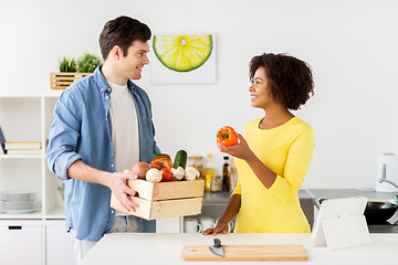 Image showing happy couple with healthy food at home kitchen