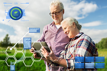 Image showing happy senior couple with tablet pc at summer farm