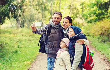 Image showing family with backpacks taking selfie by smartphone