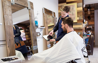 Image showing barber showing tablet pc to man at barbershop