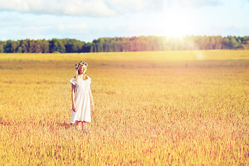 Image showing happy young woman in flower wreath on cereal field