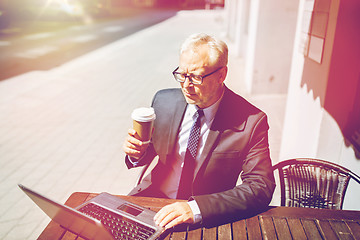 Image showing senior businessman with laptop drinking coffee