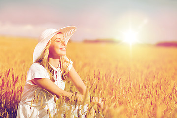 Image showing happy young woman in sun hat on cereal field