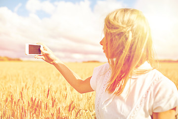 Image showing close up of girl with smartphone on cereal field