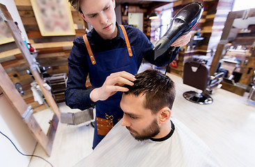 Image showing barber with fan drying male hair at barbershop