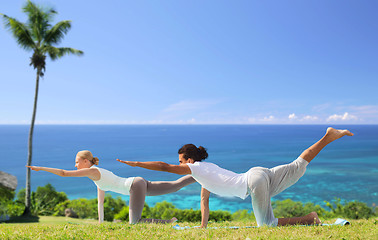 Image showing couple making yoga balancing table pose outdoors