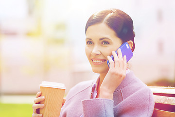 Image showing smiling woman with coffee calling on smartphone