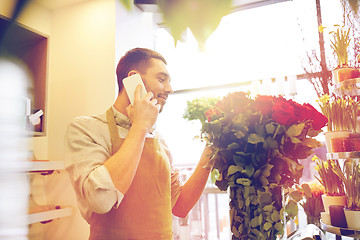Image showing man with smartphone and red roses at flower shop