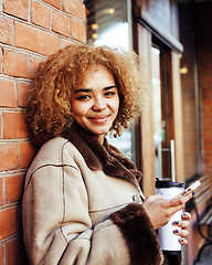 Image showing young pretty african american women drinking coffee outside in c