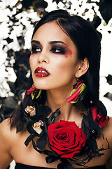 Image showing pretty brunette woman with rose jewelry, black and red, bright m