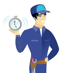 Image showing Young asian mechanic holding alarm clock.