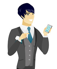 Image showing Young asian groom holding a mobile phone.