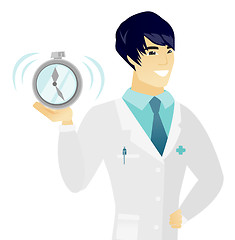 Image showing Young asian doctor holding alarm clock.