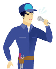 Image showing Young asian mechanic singing to the microphone.