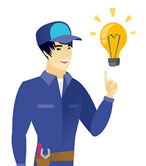 Image showing Young asian mechanic pointing at idea light bulb.